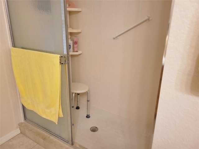 bathroom with a tile shower and tile patterned floors