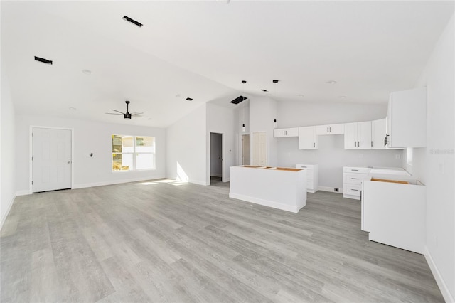 unfurnished living room featuring lofted ceiling, ceiling fan, and light wood-type flooring