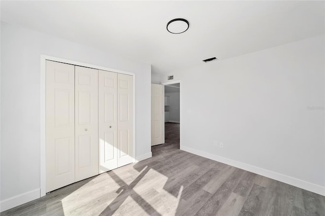 unfurnished bedroom featuring light hardwood / wood-style flooring and a closet