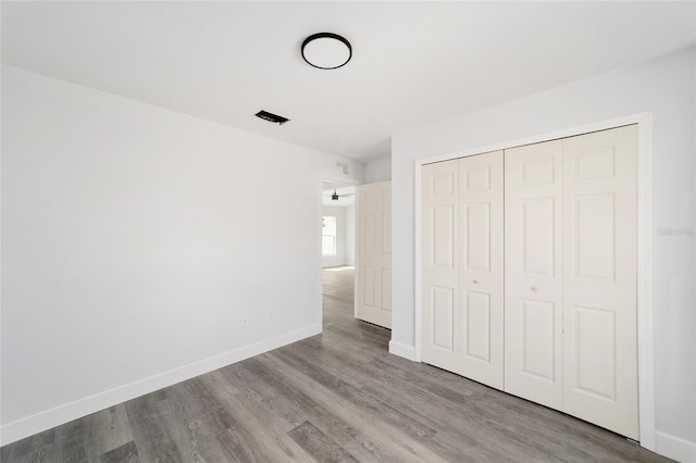 unfurnished bedroom featuring light wood-type flooring and a closet