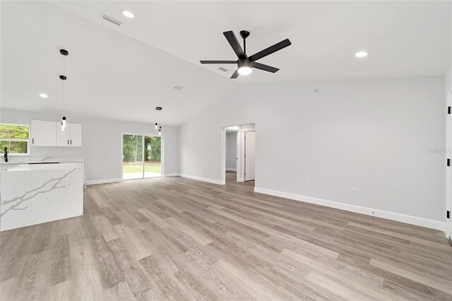 55 Locust Loop Cir, Ocala, FL 34472 - unfurnished living room with a ceiling fan, lofted ceiling, healthy amount of natural light, light wood finished floors, and recessed lighting
