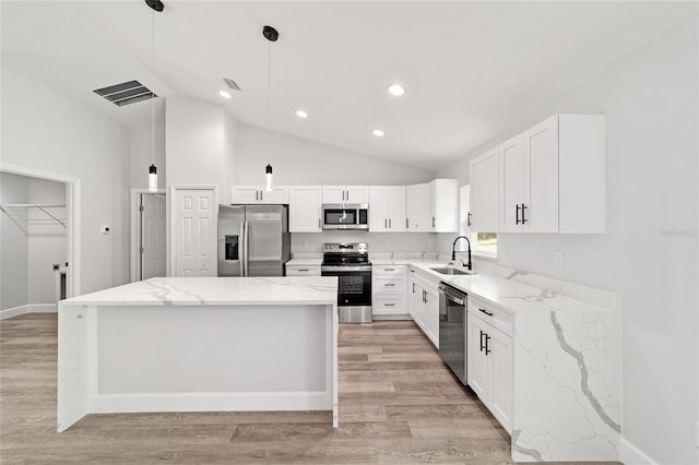 55 Locust Loop Cir, Ocala, FL 34472 - kitchen with appliances with stainless steel finishes, a center island, vaulted ceiling, light stone countertops, and light wood-type flooring