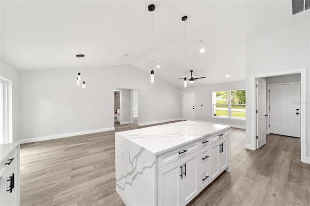 55 Locust Loop Cir, Ocala, FL 34472 - kitchen featuring vaulted ceiling, open floor plan, ceiling fan, a center island, and white cabinets