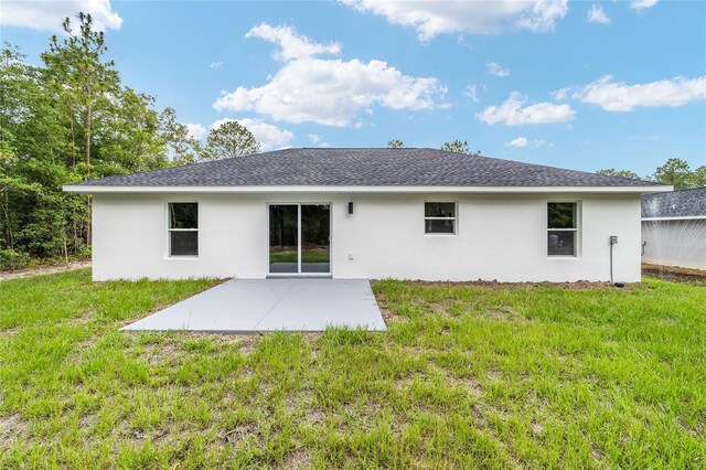 55 Locust Loop Cir, Ocala, FL 34472 - rear view of property featuring a patio area, stucco siding, a lawn, and roof with shingles