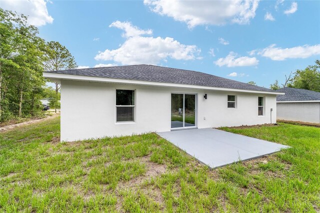 55 Locust Loop Cir, Ocala, FL 34472 - back of house featuring stucco siding, a patio area, a yard, and a shingled roof
