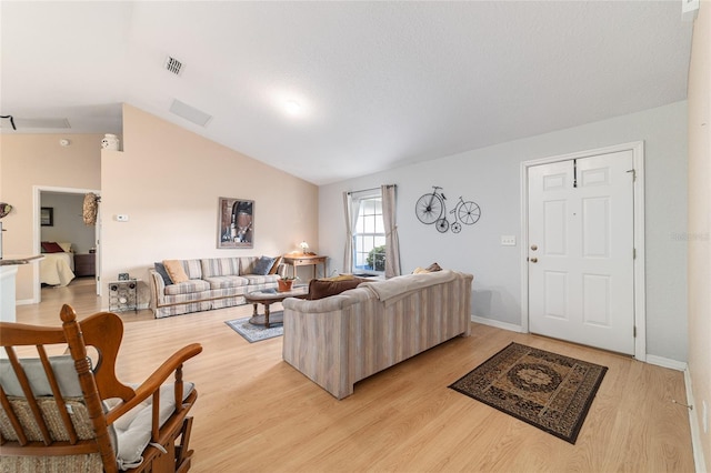 living room with vaulted ceiling and light wood-type flooring