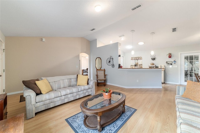 living room featuring light hardwood / wood-style flooring and vaulted ceiling