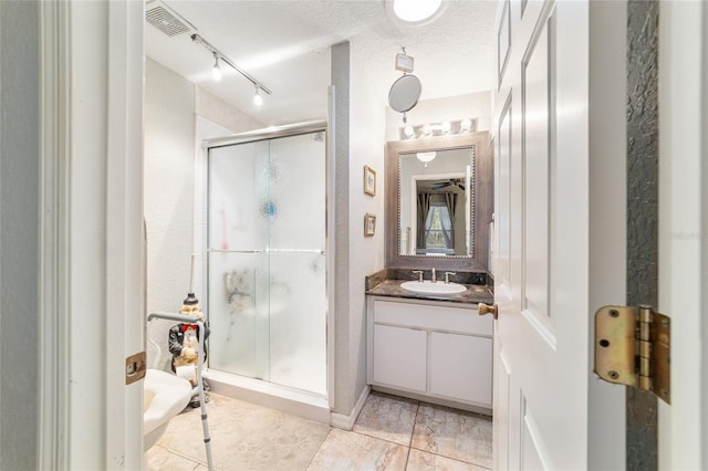 bathroom with vanity, a textured ceiling, and walk in shower