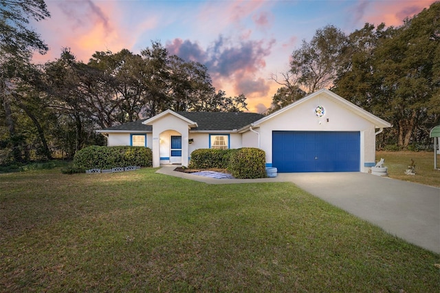 ranch-style house with a yard and a garage