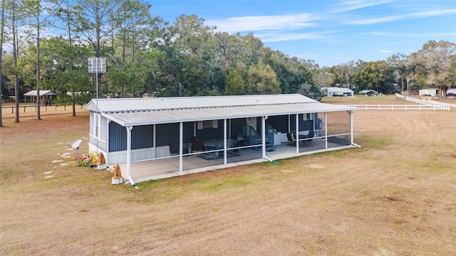 back of house with a patio, a sunroom, and a lawn