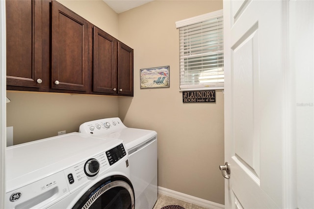 clothes washing area with cabinets and washing machine and clothes dryer