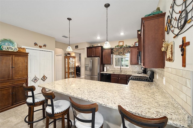 kitchen with decorative backsplash, kitchen peninsula, range, sink, and stainless steel fridge with ice dispenser