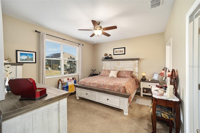 carpeted bedroom featuring a textured ceiling and ceiling fan