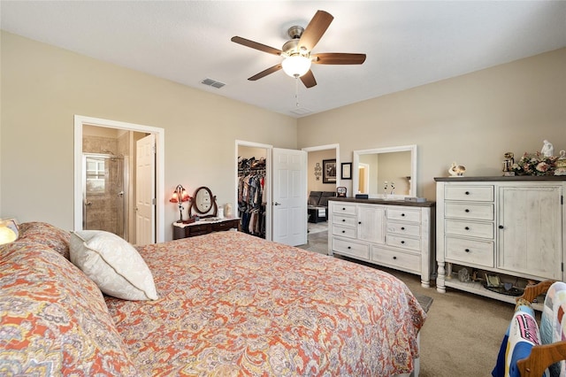 carpeted bedroom with ensuite bath, ceiling fan, a closet, and a spacious closet