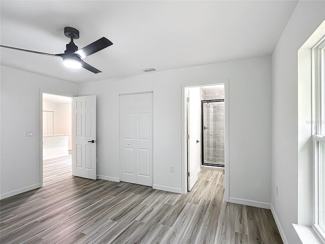 unfurnished bedroom featuring a closet, ceiling fan, light hardwood / wood-style flooring, and ensuite bathroom