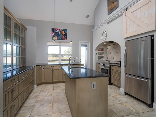 kitchen with hanging light fixtures, sink, decorative backsplash, dark stone countertops, and appliances with stainless steel finishes