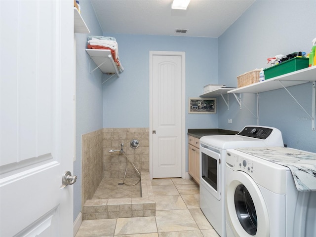 laundry room with washing machine and clothes dryer and light tile patterned flooring