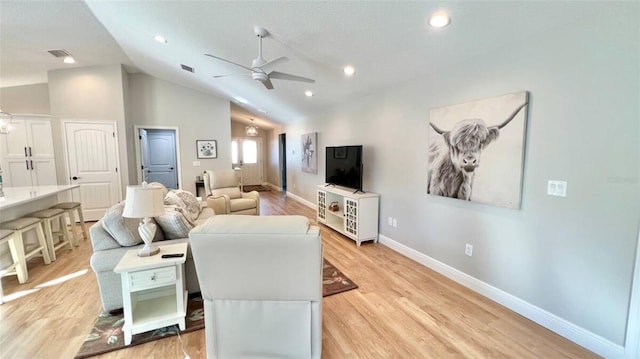 living room featuring vaulted ceiling, ceiling fan, and light hardwood / wood-style flooring