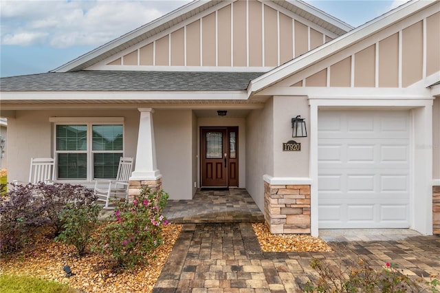 doorway to property with a porch and a garage