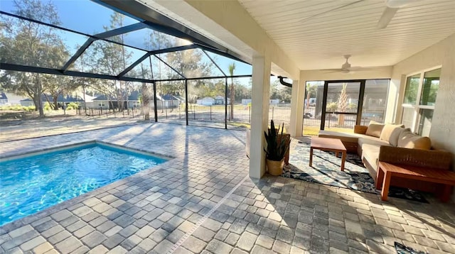 view of swimming pool featuring a lanai, ceiling fan, a patio area, and an outdoor living space