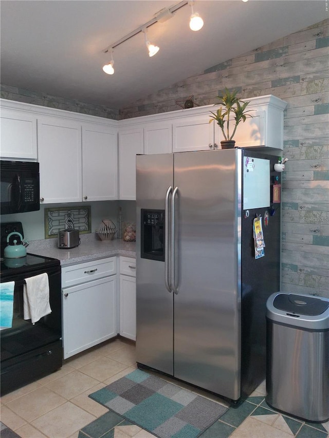 kitchen featuring white cabinets, light tile patterned floors, vaulted ceiling, and black appliances