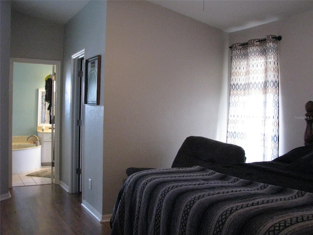 bedroom with hardwood / wood-style floors and ensuite bathroom