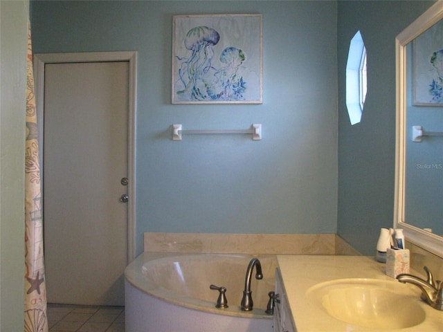 bathroom with tile patterned floors, a tub to relax in, and vanity