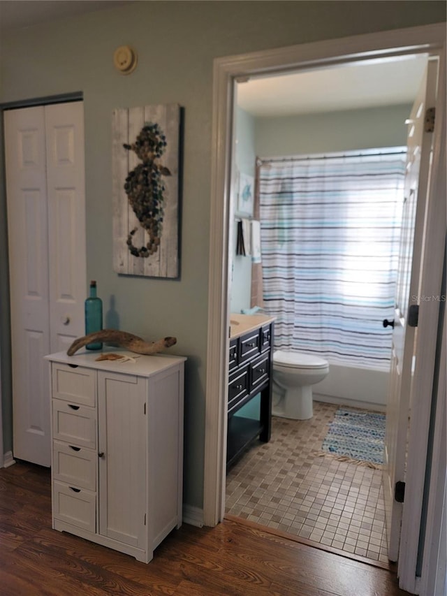 bathroom with shower / bathing tub combination, hardwood / wood-style flooring, and toilet