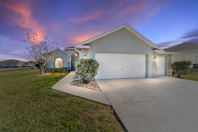 ranch-style house featuring a garage and a yard