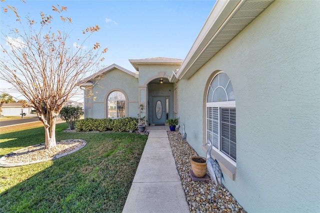 property entrance featuring a lawn