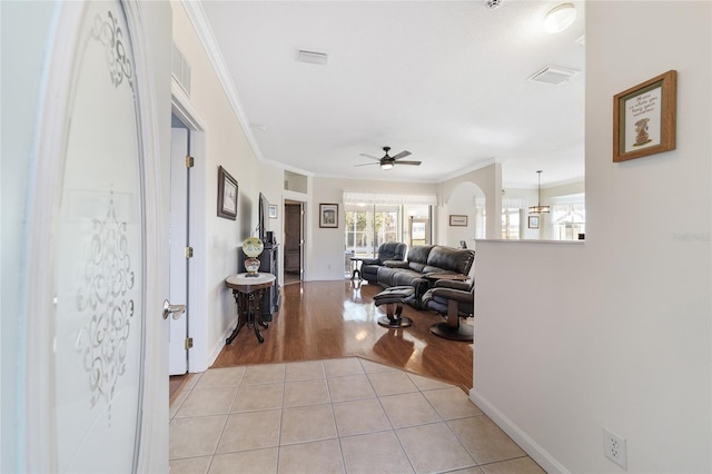 living room with light tile patterned floors, ceiling fan, and ornamental molding