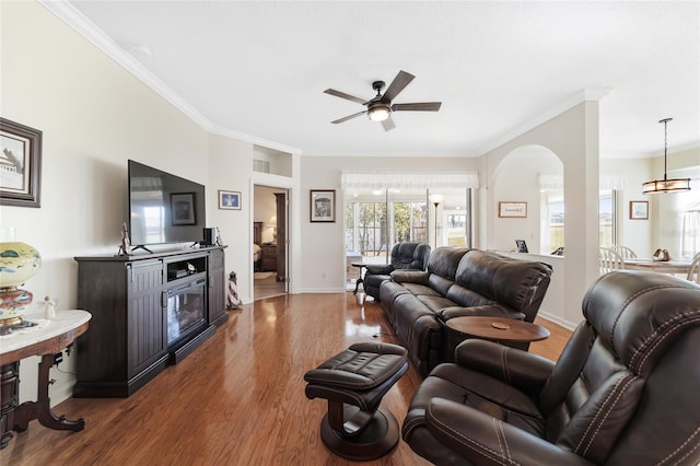 living room featuring dark hardwood / wood-style floors, ceiling fan, and crown molding