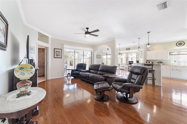 living room with ceiling fan, sink, light hardwood / wood-style floors, and ornamental molding