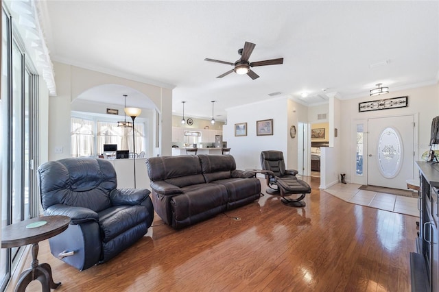 living room featuring ceiling fan, crown molding, and hardwood / wood-style flooring