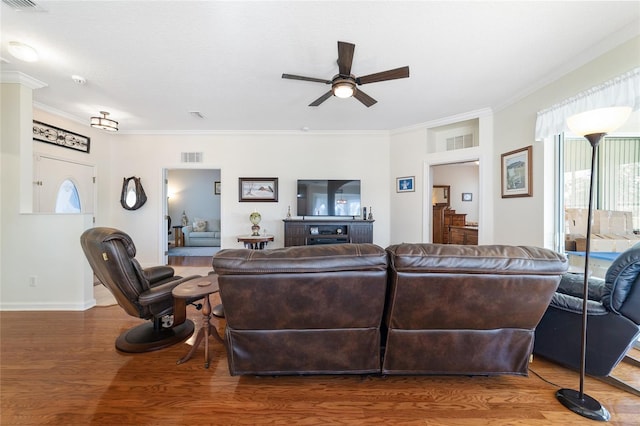 living room with ceiling fan, ornamental molding, and hardwood / wood-style flooring