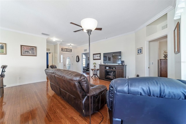 living room featuring a fireplace, wood-type flooring, a textured ceiling, and ornamental molding