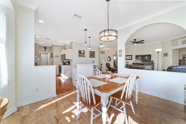 dining space with light hardwood / wood-style flooring, ceiling fan, and ornamental molding