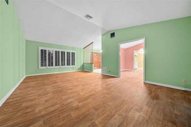 unfurnished living room with hardwood / wood-style flooring and lofted ceiling