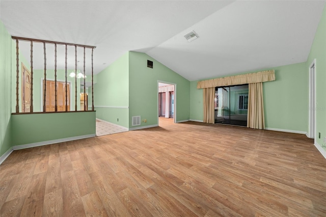 spare room with light hardwood / wood-style floors and vaulted ceiling