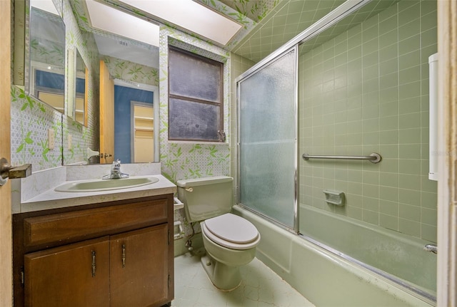 full bathroom with vanity, toilet, and combined bath / shower with glass door