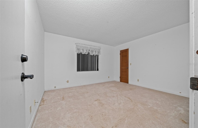 carpeted empty room featuring a textured ceiling