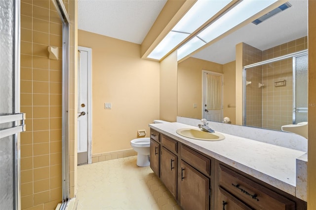 bathroom with tile patterned floors, vanity, toilet, and an enclosed shower