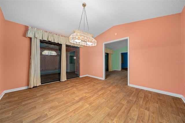 unfurnished dining area with light hardwood / wood-style floors and vaulted ceiling