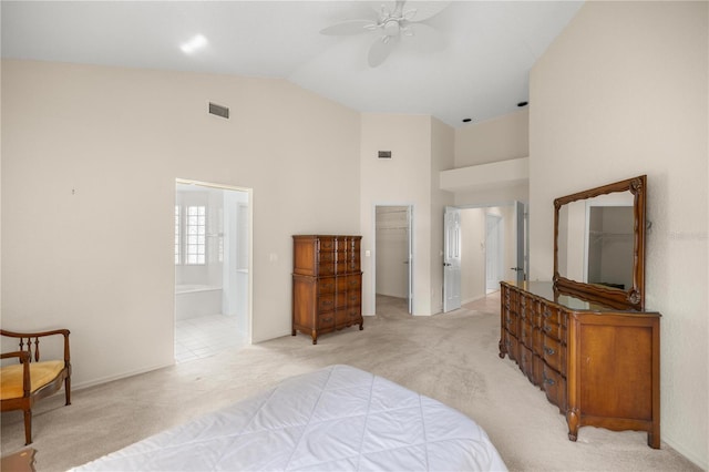 bedroom featuring light carpet, ensuite bath, ceiling fan, a closet, and lofted ceiling