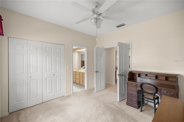 office space featuring light carpet and ceiling fan