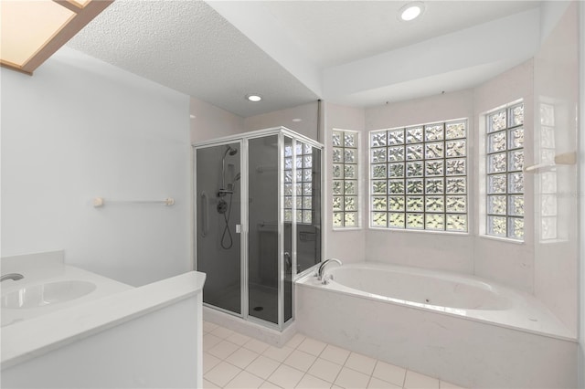 bathroom with tile patterned floors, plus walk in shower, a textured ceiling, and a wealth of natural light