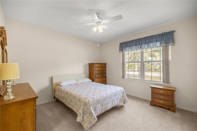 carpeted bedroom with ceiling fan and a textured ceiling