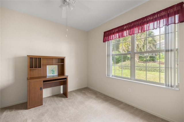 unfurnished office with light carpet, ceiling fan, and a healthy amount of sunlight