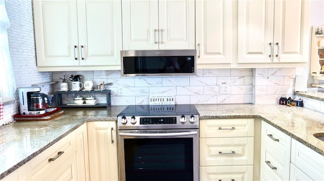 kitchen with stainless steel appliances, decorative backsplash, and light stone countertops