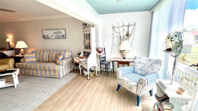 living area with ornamental molding and hardwood / wood-style flooring